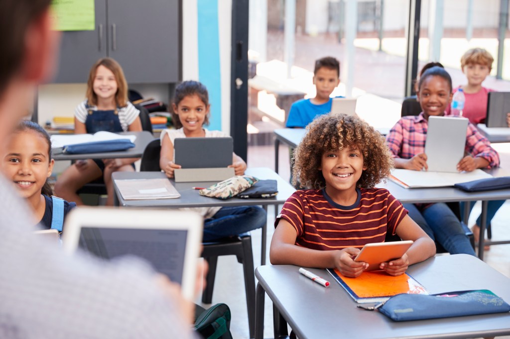 Elementary students looking at teacher, over shoulder view