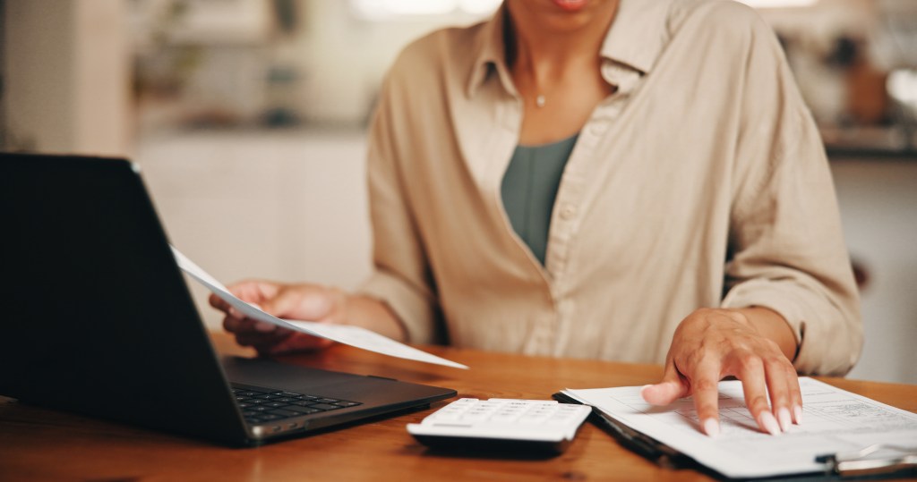 Woman, hands and document in apartment with laptop, calculator and working on online enrollment.